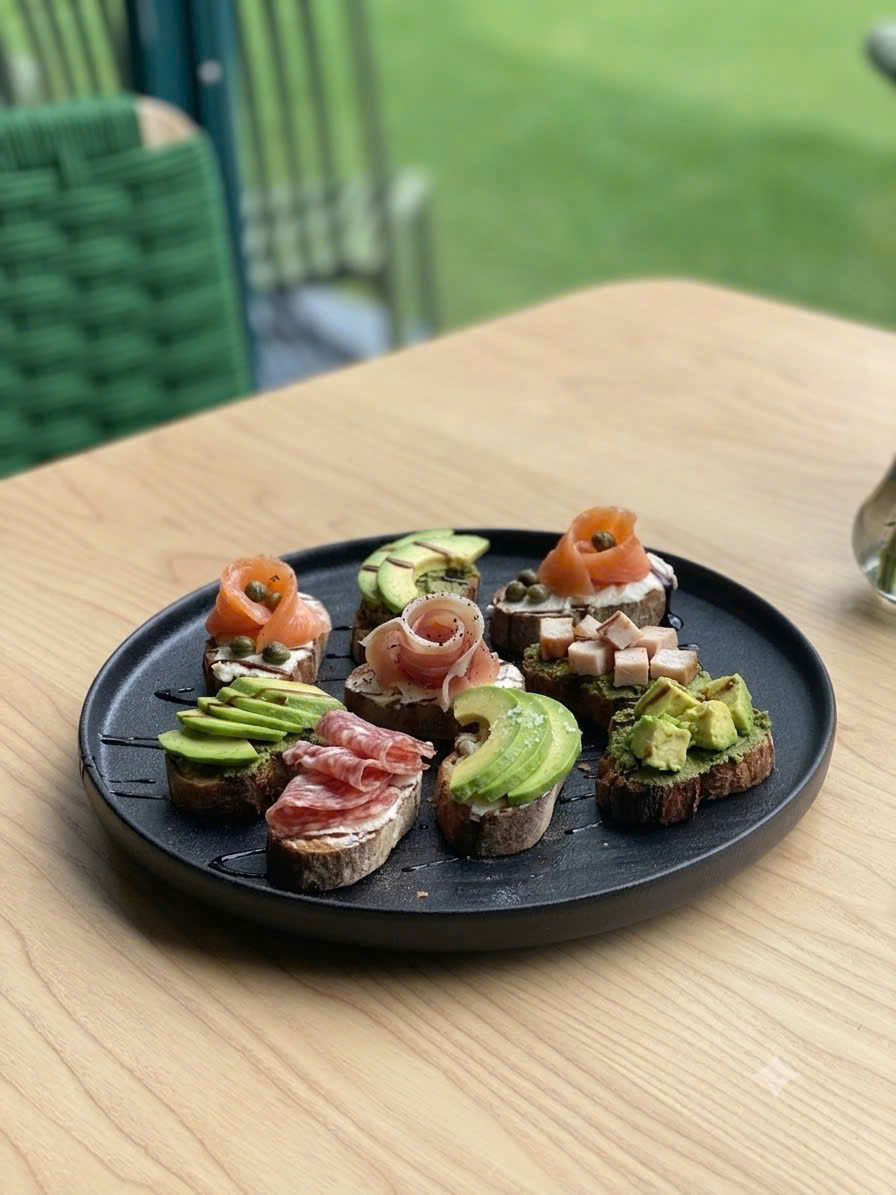 Botanical canapé board with smoked salmon, avocado, and bruschetta bites